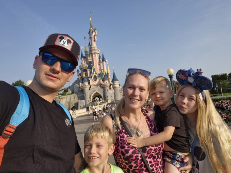 Gezin met vier kinderen voor het kasteel in Disneyland