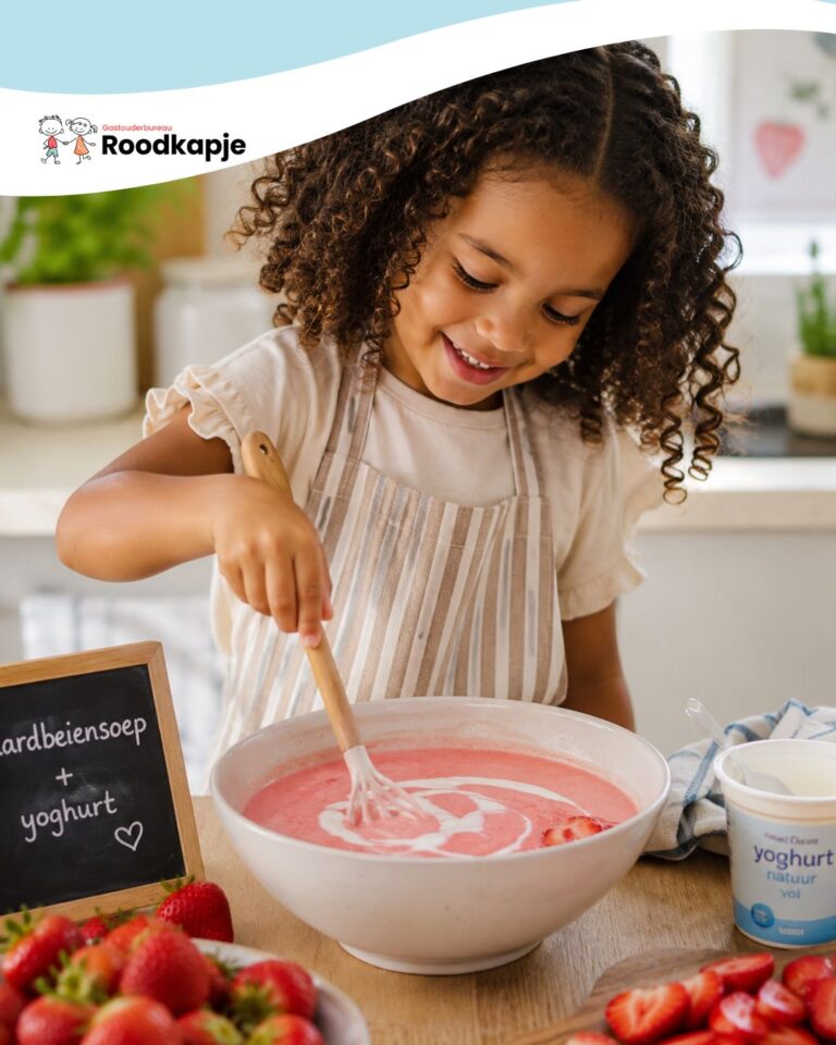 Meisje roert een kom zomerse aardbeiensoep